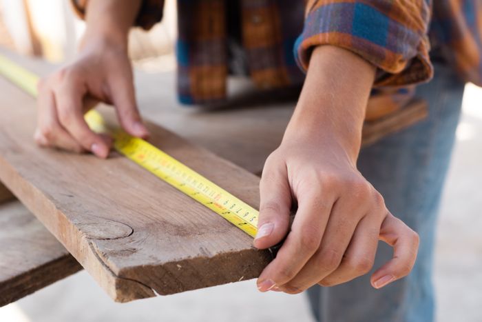 Carpenter measuring wood on a Ferren Construction project